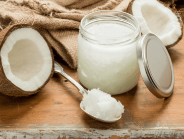 a coconut in half, and a coconut oil jar with spoon