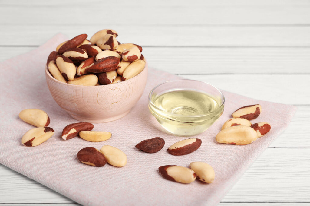 bowl of whole brazil nuts and small bowl of brazil nut oil
