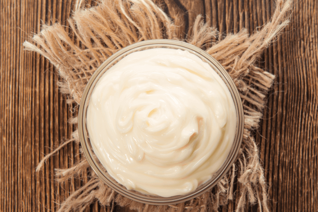 bowl of mayonnaise hair mask on brown background