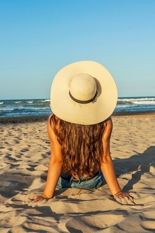 beach vacation hairstyle with sunhat